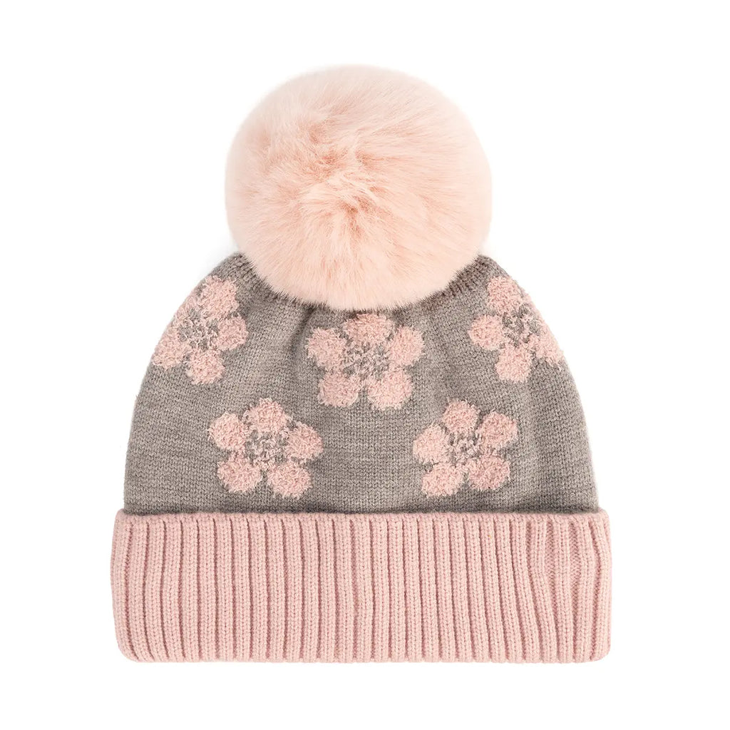 A knit pom-pom beanie hat featuring a gray body with pink floral patterns and a ribbed light pink cuff, topped with a fluffy light pink faux-fur pom-pom.