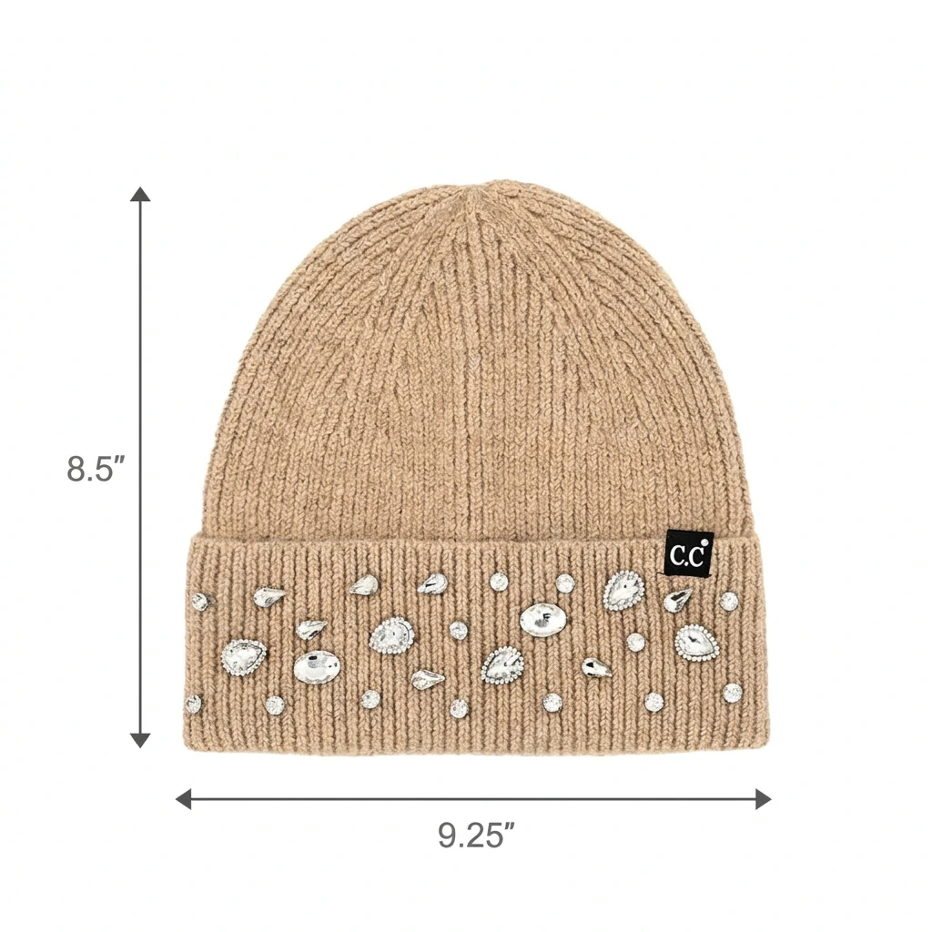 A beige ribbed knit beanie hat with a folded cuff decorated with scattered white shell-shaped embellishments and small rhinestone-like studs. Black dimension arrows and text.