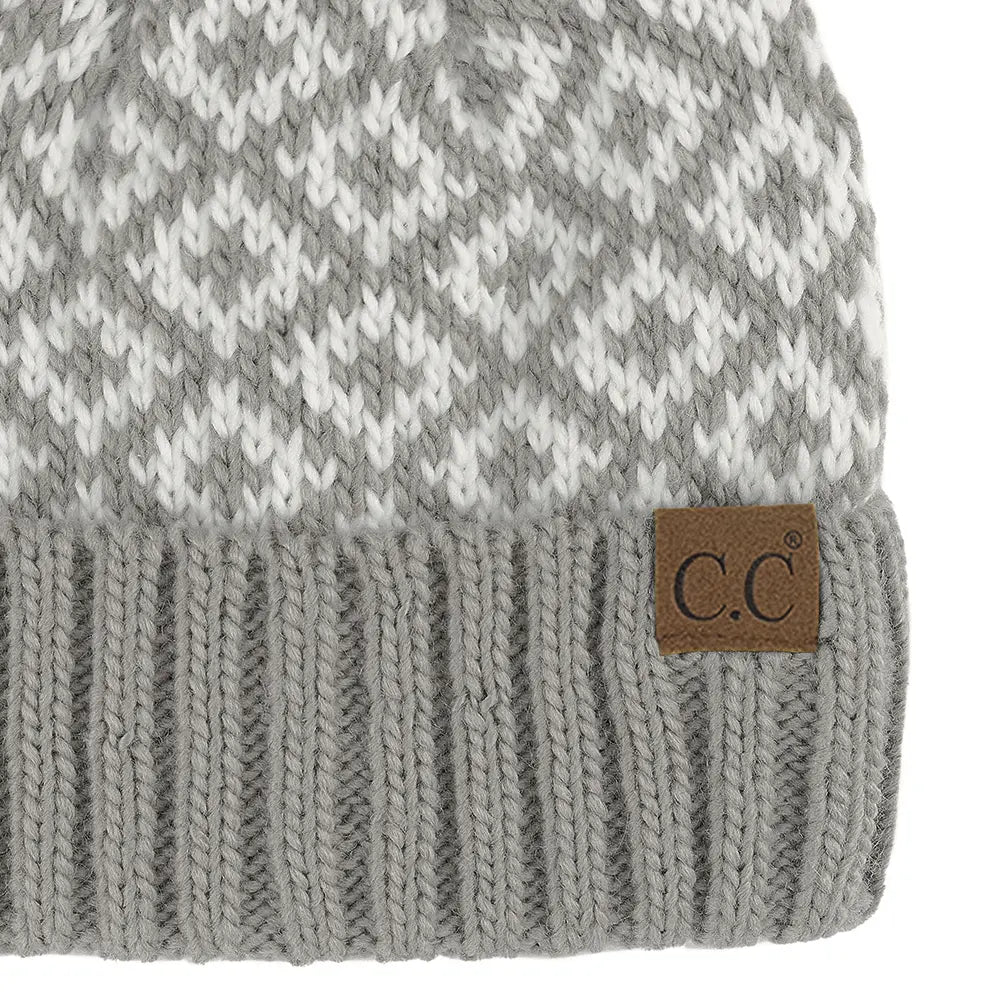 Close-up of a gray and white patterned knit beanie with a ribbed cuff and a brown leather patch featuring the 'C.C' logo.