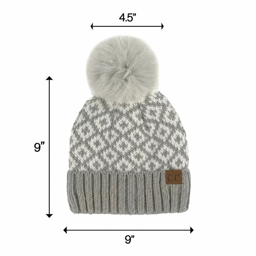 A gray and white patterned knit beanie with a large light gray pom-pom, shown with dimension arrows and labels indicating 9 inches height, 9 inches width, and 4.5 inches top diameter on a white background.