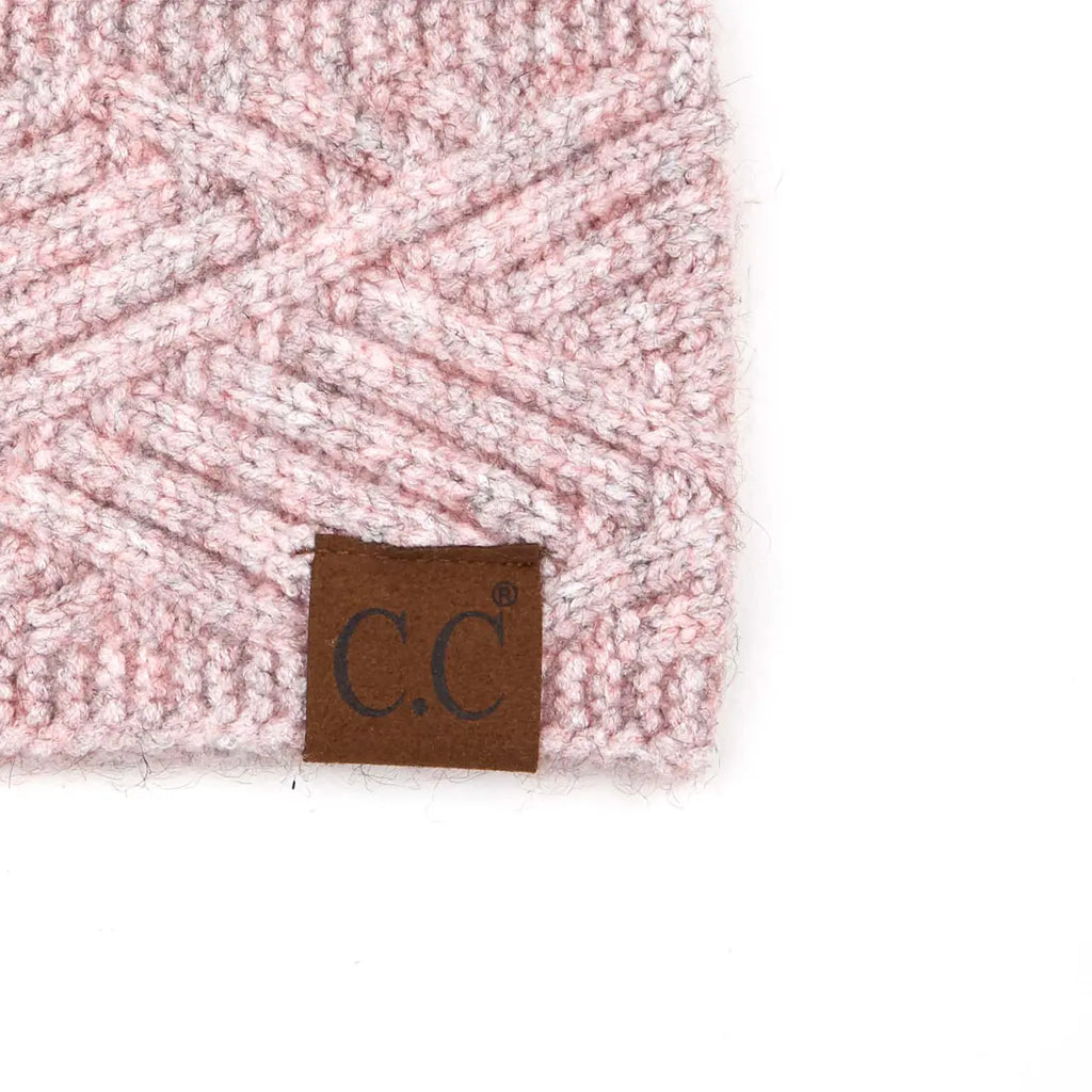 Close-up of a pink and white textured knit beanie with a brown leather brand patch reading 'C.C' on a white background.