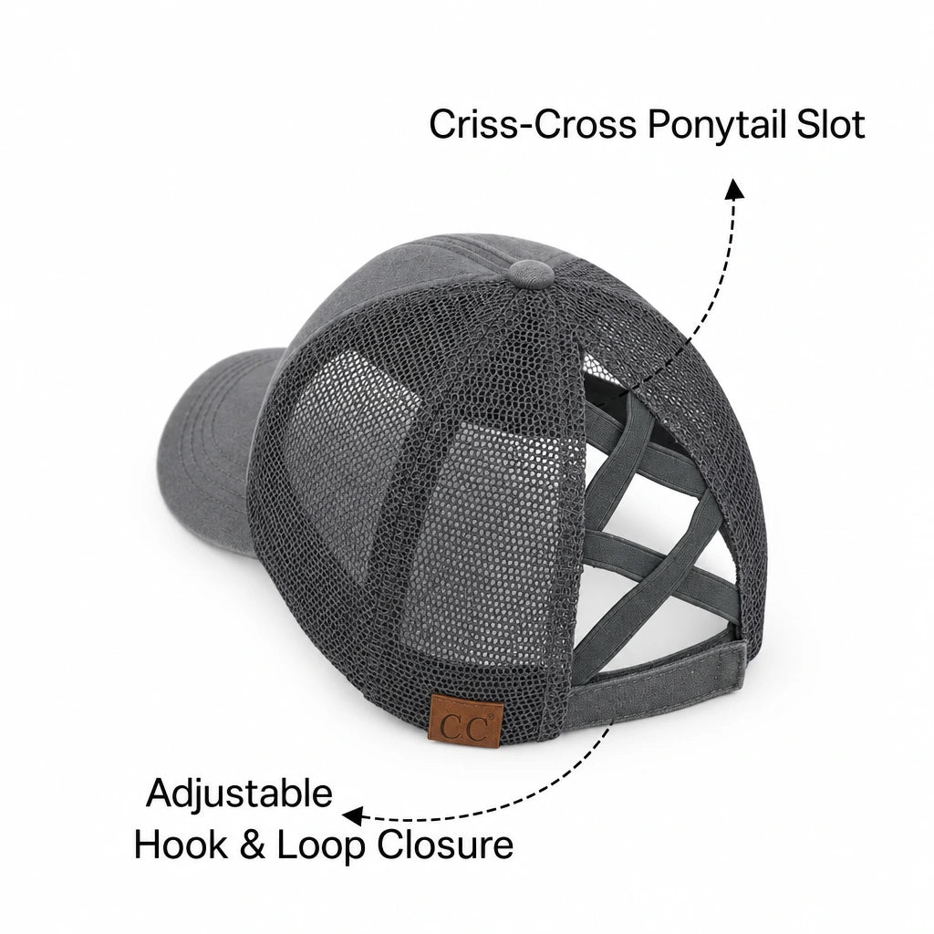 A dark gray distressed trucker hat with a mesh back, shown from a rear three-quarter angle with text callouts reading 'Criss-Cross Ponytail Slot' and 'Adjustable Snapback'.